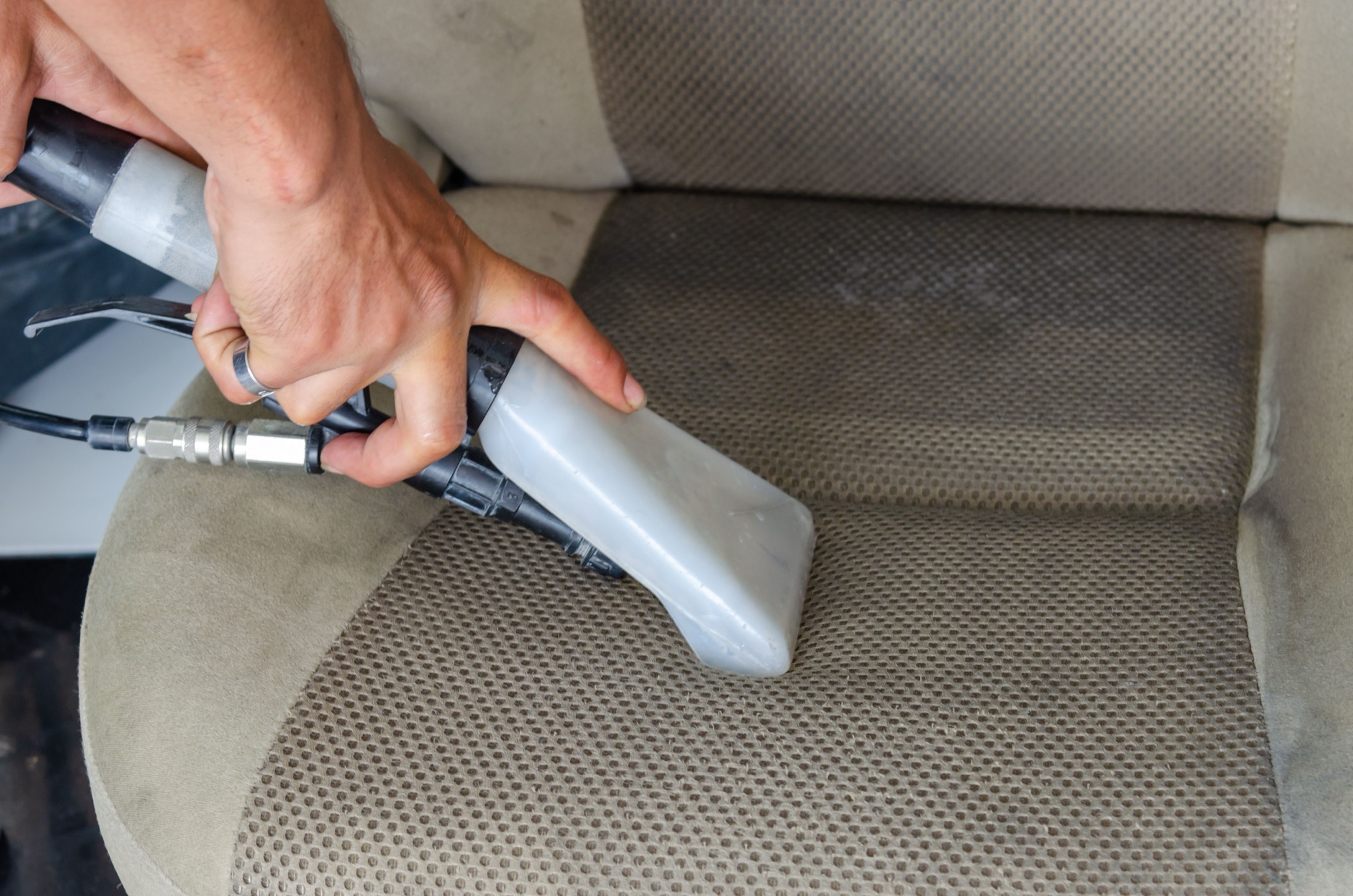 Detailing tool cleaning a vehicle seat